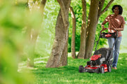 Outdoor photo of CRAFTSMAN CM12ABO2C2093 lawn mower in use under trees cutting green grass.