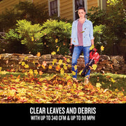 Photo of Craftsman leaf blower CMCBL700B clearing autumn leaves in a yard, held by person near stone wall.