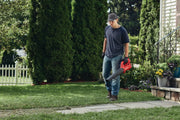 Photo of Craftsman CMCBL710D1 leaf blower in use outdoors, red handheld design, garden setting.