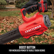 Photo of Craftsman cordless leaf blower CMCBL720M1, close-up of handle and boost button, used outdoors on lawn.