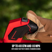 Close-up photo of a Craftsman CMCBL730P1 handheld blower grip with a gloved hand pressing the boost button outdoors.