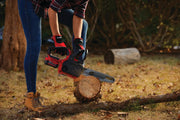 Photo of CRAFTSMAN chainsaw CMCCS620B cutting a log outdoors, held by a person wearing gloves.