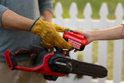 Photo of CRAFTSMAN CMCCS630P1 cordless chainsaw cutting a log outdoors, person wearing red gloves.