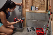Photo of person using a CRAFTSMAN cordless drill CMCD716 to install a metal bracket, with drill bit set on nearby floor.