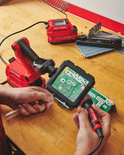 Photo of Craftsman CMCE020B soldering station with magnifier used on a circuit board, red tools visible on bench.