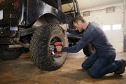 Photo of Craftsman CMCF920B impact driver in use on SUV tire in garage, red and black tool visible.