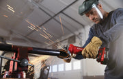 Photo of Craftsman CMCG450B cordless grinder cutting metal pipe, sparks flying, operator wearing gloves and face shield.