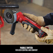 Photo of Craftsman CMCG450B cordless angle grinder with paddle switch, shown in use with gloved hands.