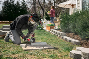 Photo of Craftsman CMCG452B grinder used outdoors to cut concrete blocks during landscaping.