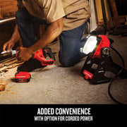 Photo of Craftsman work light CMCL030B in use on the floor, projecting bright light, with worker using power tools nearby.