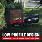 Photo of Craftsman lawn mower CMCMW220P2 with low-profile design, cutting grass under a raised planter outdoors.