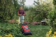 Photo of Craftsman lawn mower CMCMWP120M2 in use outdoors, red and black, pushing through green grass.