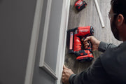 Photo of a Craftsman cordless nailer, SKU CMCN623B, being used to install baseboard on wood floor.