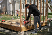 Photo of CRAFTSMAN CMCN630PTB cordless nail gun in use on wood framing, outdoor construction setting.