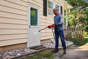 Photo of CRAFTSMAN cordless power washer CMCPW350D1 used outdoors near a house door.
