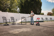 Photo of CRAFTSMAN CMEPW1900 pressure washer cleaning outdoor metal chair on driveway, shown in use.