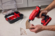 Photo of Craftsman cordless glue gun CMGL200B in use, with accessory case and glue sticks on tile floor.