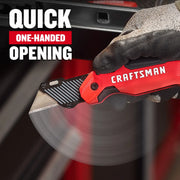 Close-up of Craftsman utility knife CMHT10353 with red and black handle, gloved hand shows quick one-handed opening.