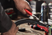 Photo of Craftsman diagonal cutting pliers CMHT82508 with red handles cutting a black zip tie around electrical wires.