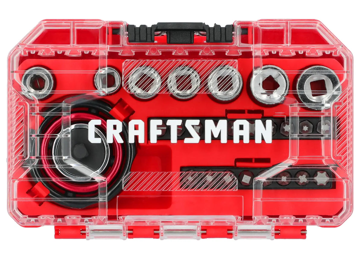 A clear plastic case with red interior containing a Craftsman socket and bit set. The set includes sockets, bits, and a ratchet with the Craftsman logo prominently displayed inside.