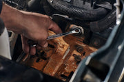 Photo of CRAFTSMAN wrench CMMT87300V in use on a rusty metal surface, automotive context, close-up view.