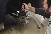 Photo of a person using a CRAFTSMAN screwdriver on a car brake caliper, with additional tools and CMMT98347 SKU visible nearby.