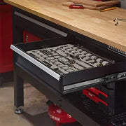 Craftsman graphics CMST27202BK drawer with organized sockets under wooden workbench, angled view.