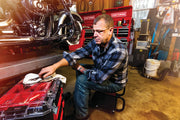 Photo of a man working on a motorcycle in a garage with Craftsman toolboxes and red Craftsman CMST60403 organizer visible.