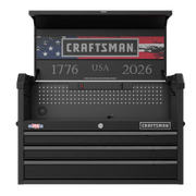 Front view of a black Craftsman tool chest with its lid open, featuring an American flag design and the years 1776 and 2026 printed above the drawers. The chest includes multiple drawers, pegboard backing, and power outlets. Craftsman logos are visible on both the top interior and bottom drawer.