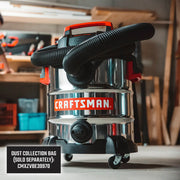 Photo of Craftsman stainless steel wet/dry vacuum, SKU CMXEVBE17155, with black hose in workshop setting.