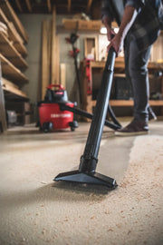Photo of a CRAFTSMAN wet/dry vacuum CMXEVBE17584 cleaning sawdust from a workshop floor, vacuum in use.