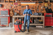 Photo of CRAFTSMAN wet/dry vacuum, SKU CMXEVBE17596, in a workshop setting with person holding hose.