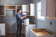 Photo of Craftsman CMXEVBE17678 wet/dry vacuum in use cleaning white cabinets in a kitchen renovation.