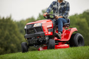 Photo of Craftsman riding lawn mower CMXGRAM201302 on grass, front angle view, red color, outdoor use.