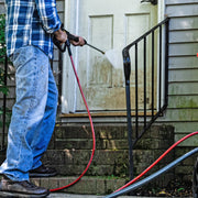 Photo of person using Craftsman CMXGWFN061325 pressure washer on a dirty door and porch steps.