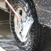 Photo of Craftsman brush CMXMLBA7210A cleaning a soapy car tire and wheel.