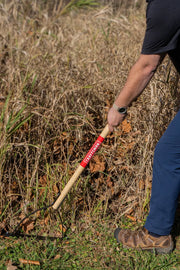 Photo of CRAFTSMAN garden hoe CMXMLTP35318 with wooden handle in use on grassy ground.