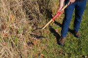 Photo of Craftsman garden hoe CMXMLTP35318 with wooden handle used on dry grass outdoors.