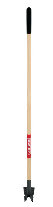A manual garden cultivator with a long wooden handle, a black grip at the top, and a metal clawed head at the bottom for loosening soil. The handle has a red label with white text.
