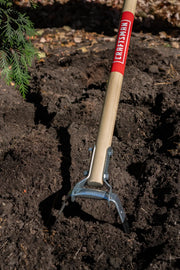 Photo of Craftsman garden cultivator CMXMLTP35323 with wooden handle in soil outdoors.