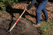 Photo of Craftsman garden hoe CMXMLTP35323 with wooden handle in use on soil outdoors.