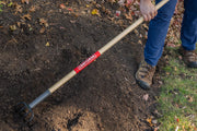Photo of CRAFTSMAN garden cultivator, SKU CMXMLTP35328, with wood handle and metal tines, used on soil outdoors.