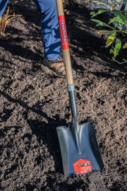 Photo of Craftsman shovel CMXMLTP35330 with wooden handle digging in soil, close-up outdoor gardening scene.