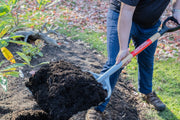 Photo of Craftsman garden shovel CMXMLTP35332 scooping mulch in outdoor landscaping setting.