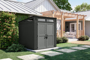 Photo of Craftsman outdoor storage shed CMXRCSCBMSCM7750, dark gray, in a landscaped backyard setting.