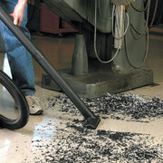 Photo of Craftsman wet/dry vacuum cleaning debris, SKU CMXZVBE38606, used on workshop floor near machine.