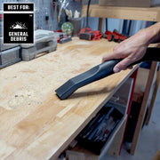 Photo of a hand using a CRAFTSMAN CMXZVBE38755 vacuum nozzle cleaning general debris on a wooden workbench in a workshop.